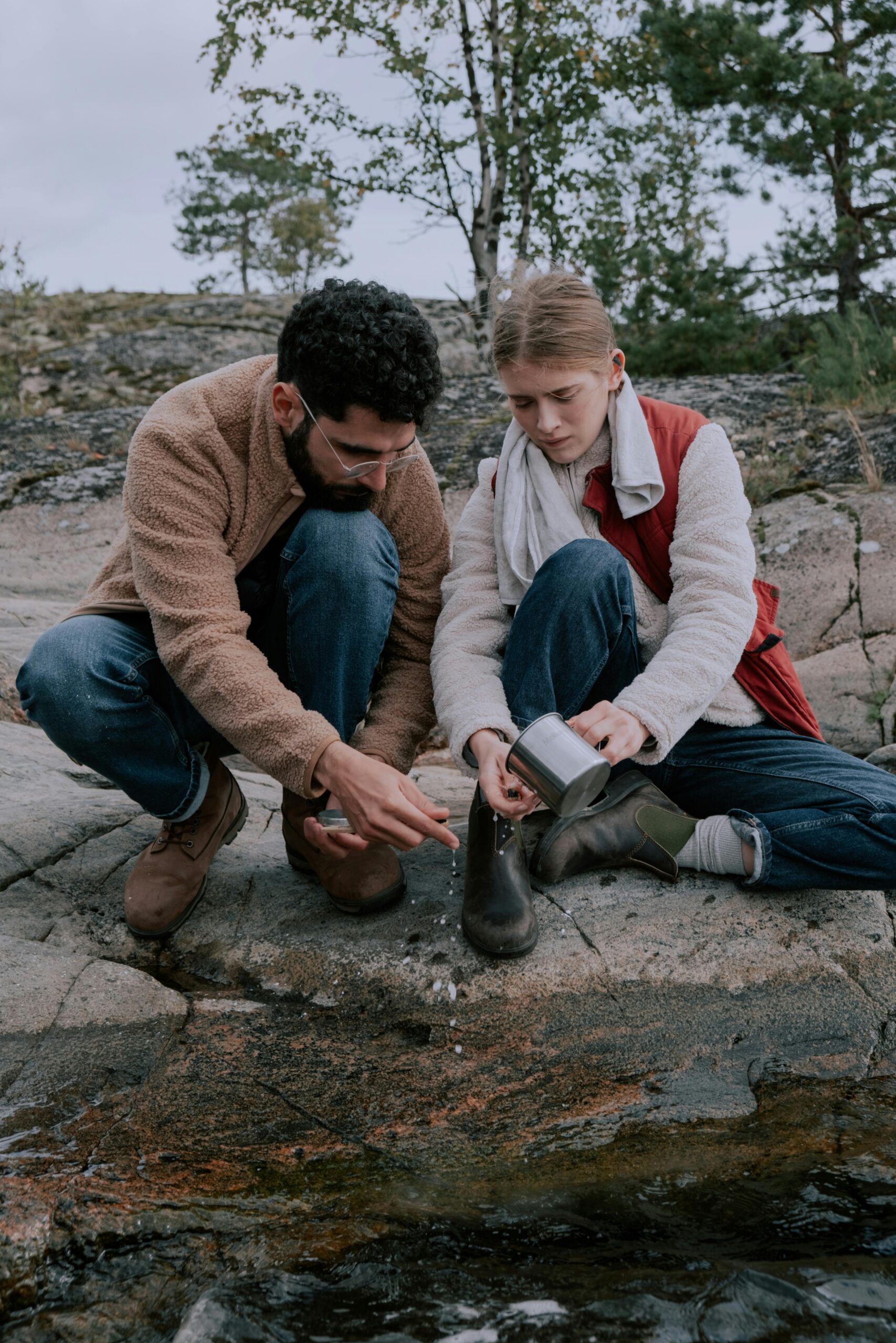 A couple purifies water together during an outdoor adventure in nature.